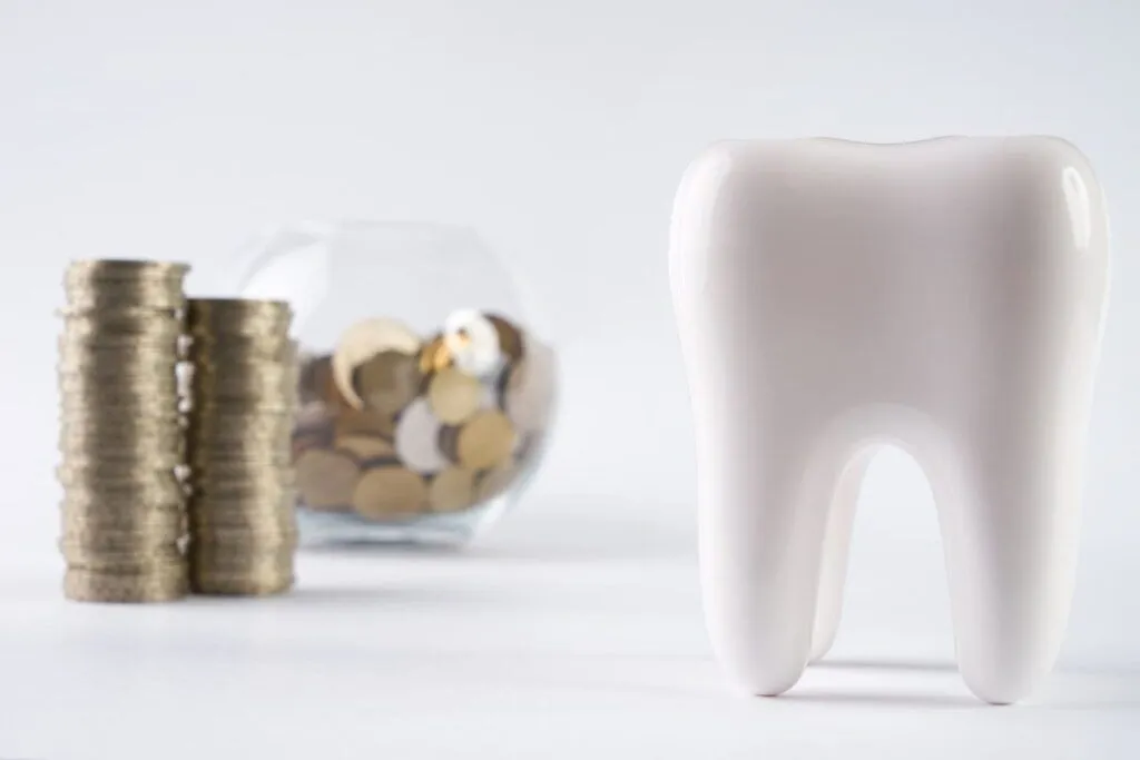 Tooth and piggy box with coins on isolate white background.Financial Concept Dentist Money concept