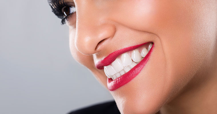 Cosmetic dentistry has the power to improve all aspects of your life! Close up of young woman smiling with the benefits of cosmetic dentistry.