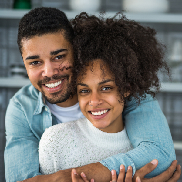A young couple showing off their new smile after their porcelain veneers treatment