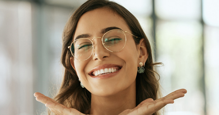 Cosmetic Dentistry in Mukilteo, WA A young female wearing glasses smiles as she closes her eyes