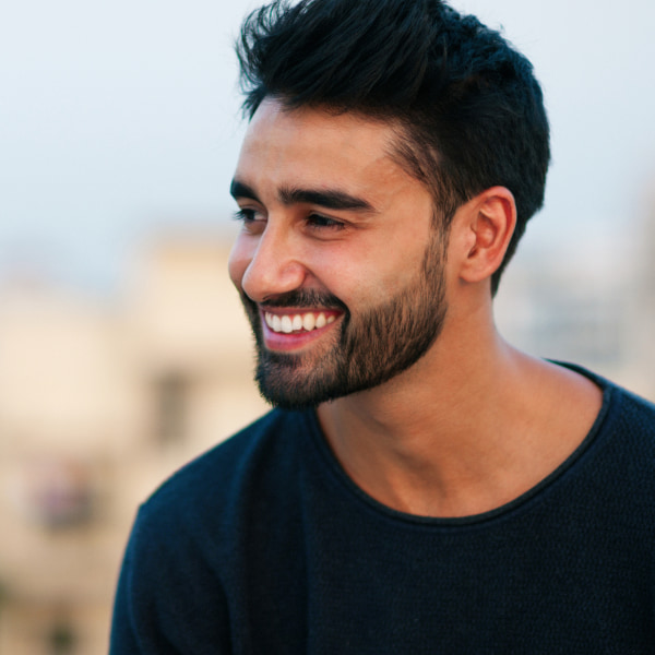 A bearded man smiling outside