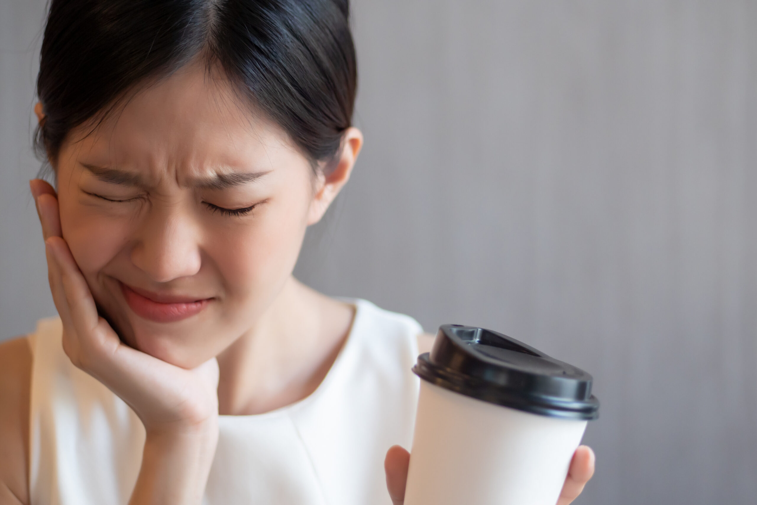 Woman experiencing tooth sensitivity discomfort