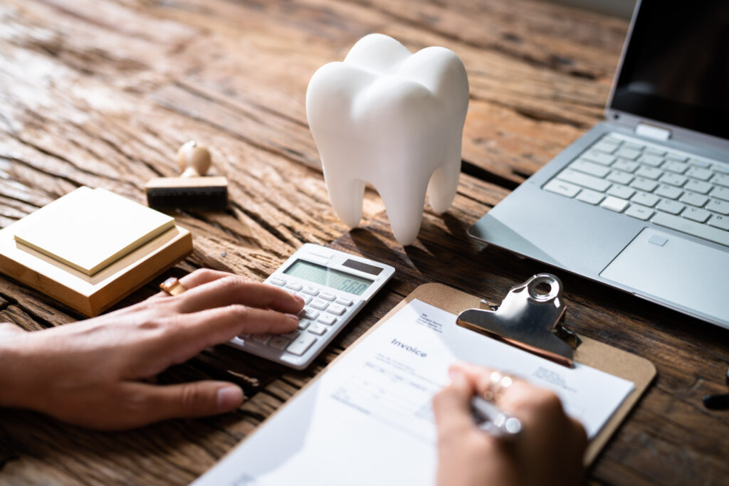 Dentist and patient reviewing dental insurance paperwork at front desk